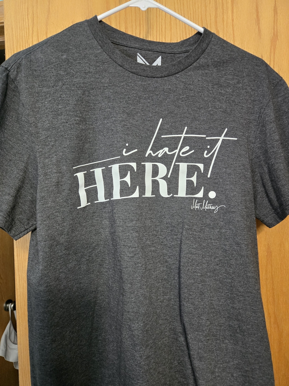 Matt Mathews Tee with "I Hate It Here." Slogan